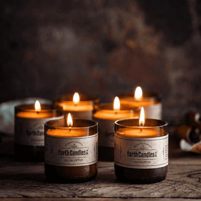 Six Eucalyptus soy tealights burning together in cut amber beer bottle bases