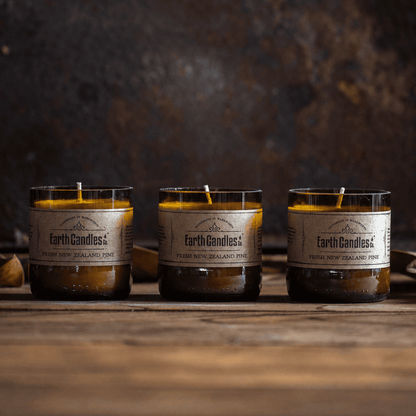 Three Fresh New Zealand Pine soy tealights by Earth Candles Co., unlit, in cut amber beer bottle bases