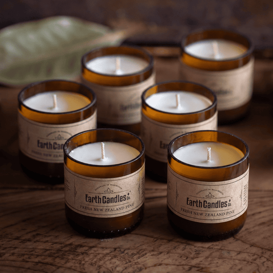 Six Fresh New Zealand Pine soy tealights, unlit, grouped in their cut amber beer bottle bases