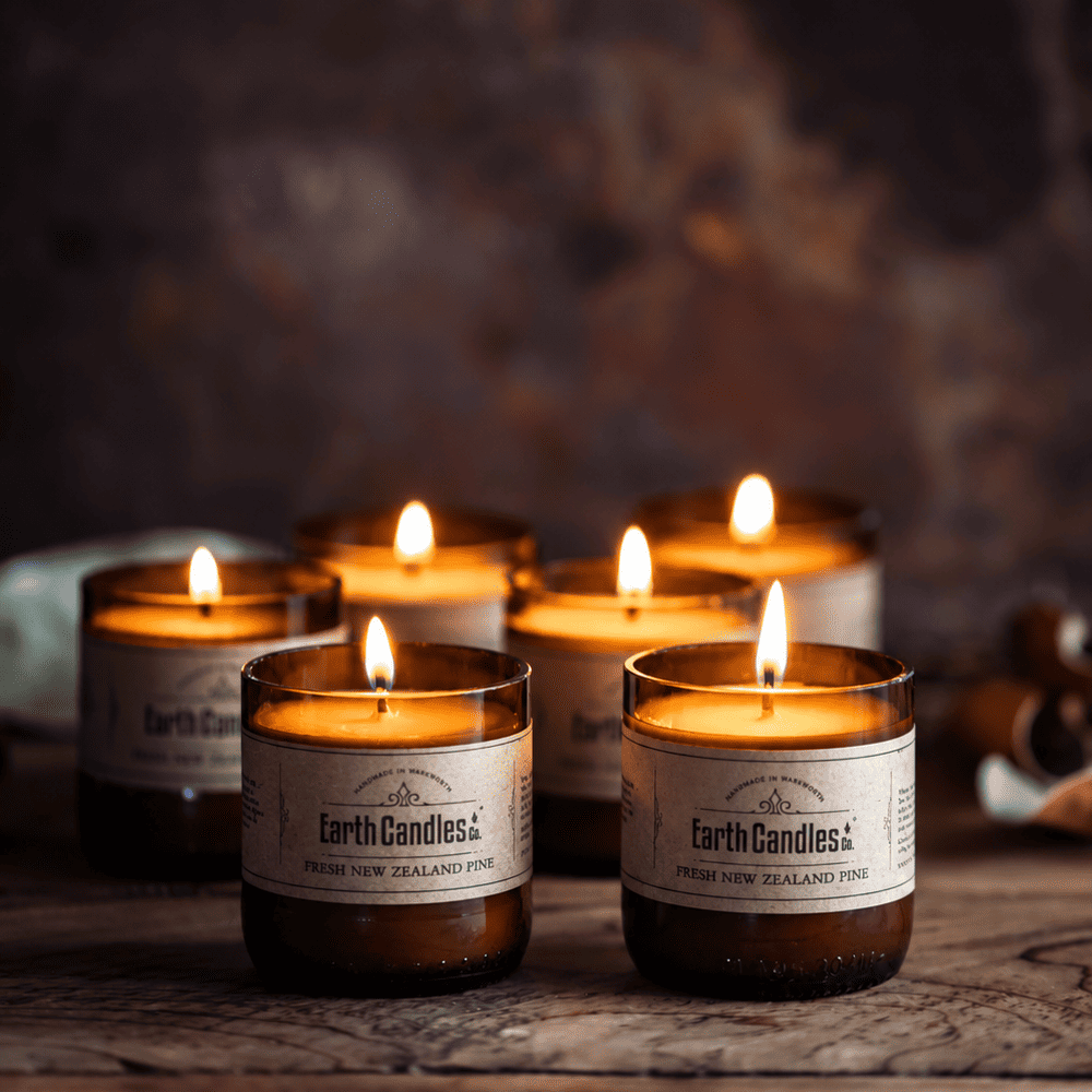 Six Fresh New Zealand Pine soy tealights burning in cut amber beer bottle bases