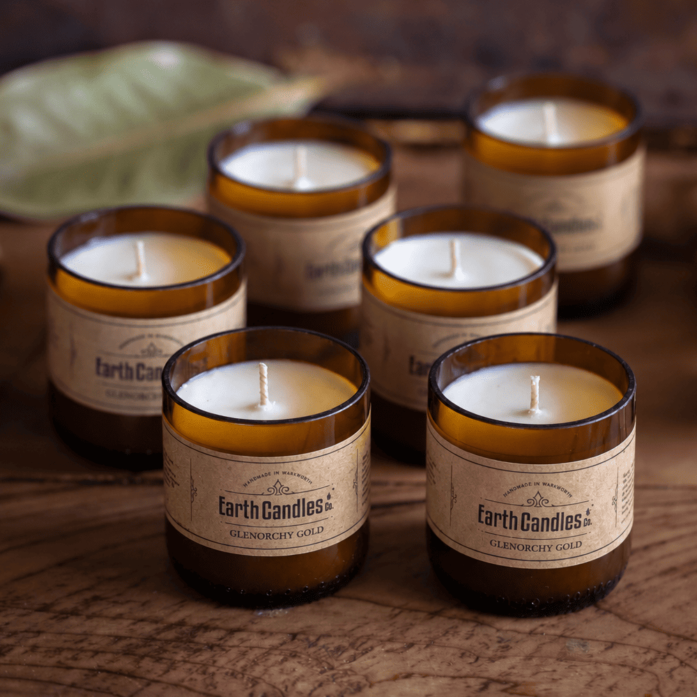Six Glenorchy Gold soy tealights, unlit, grouped in their cut amber beer bottle bases