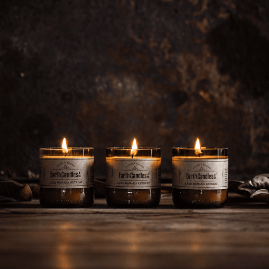 Three Lake Wanaka Retreat soy tealights burning in a row in cut amber beer bottle bases